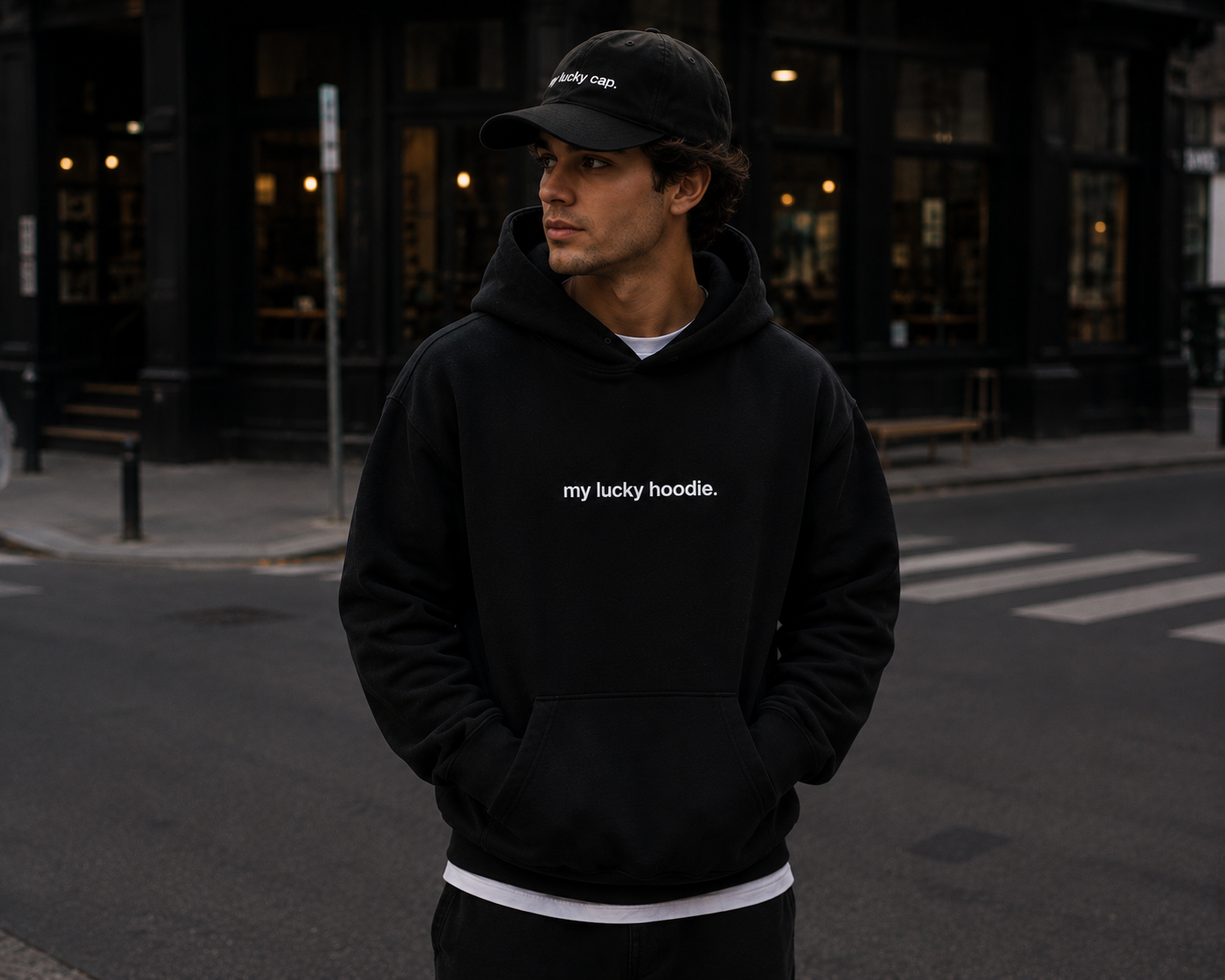 Man in MY LUCKY hoodie and cap on a city street